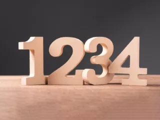 Wood cutouts of the numbers 1, 2, 3, and 4 on a table