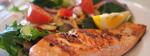 Baked salmon, tomatoes, lemon, and greens