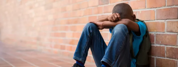 Frustrated student sitting by wall