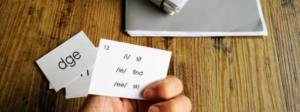 Hand holding phonics flashcards