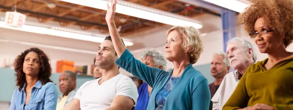 Frustrated teacher raising hand in meeting